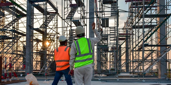 Two-construction-workers-discussing-an-active-building-site-financed-with-a-commercial-construction-loan.-1